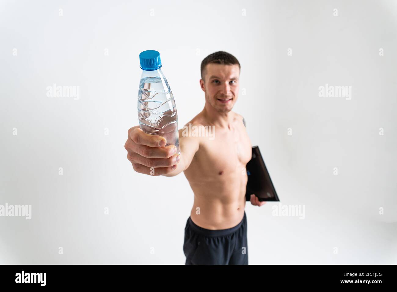 Homme boire-eau fitness est pompé avec une serviette sur un fond blanc fitness isolé eau musculaire saine gym homme sportif, sportif cardio. prot Banque D'Images