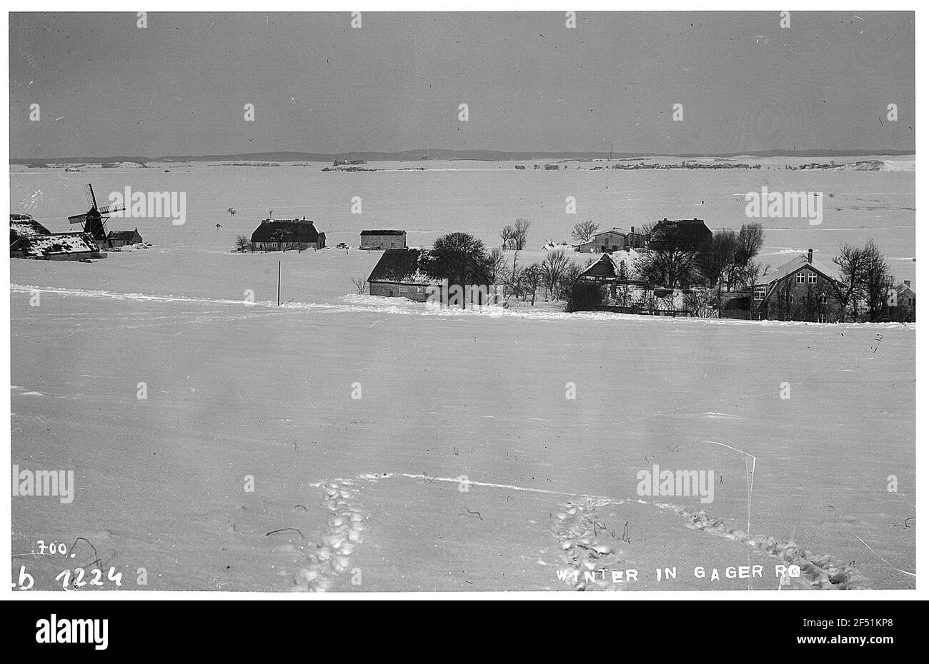 Gager, Rügen / Allemagne: Local en hiver. Vue sur le paysage enneigé avec maisons et moulin Banque D'Images