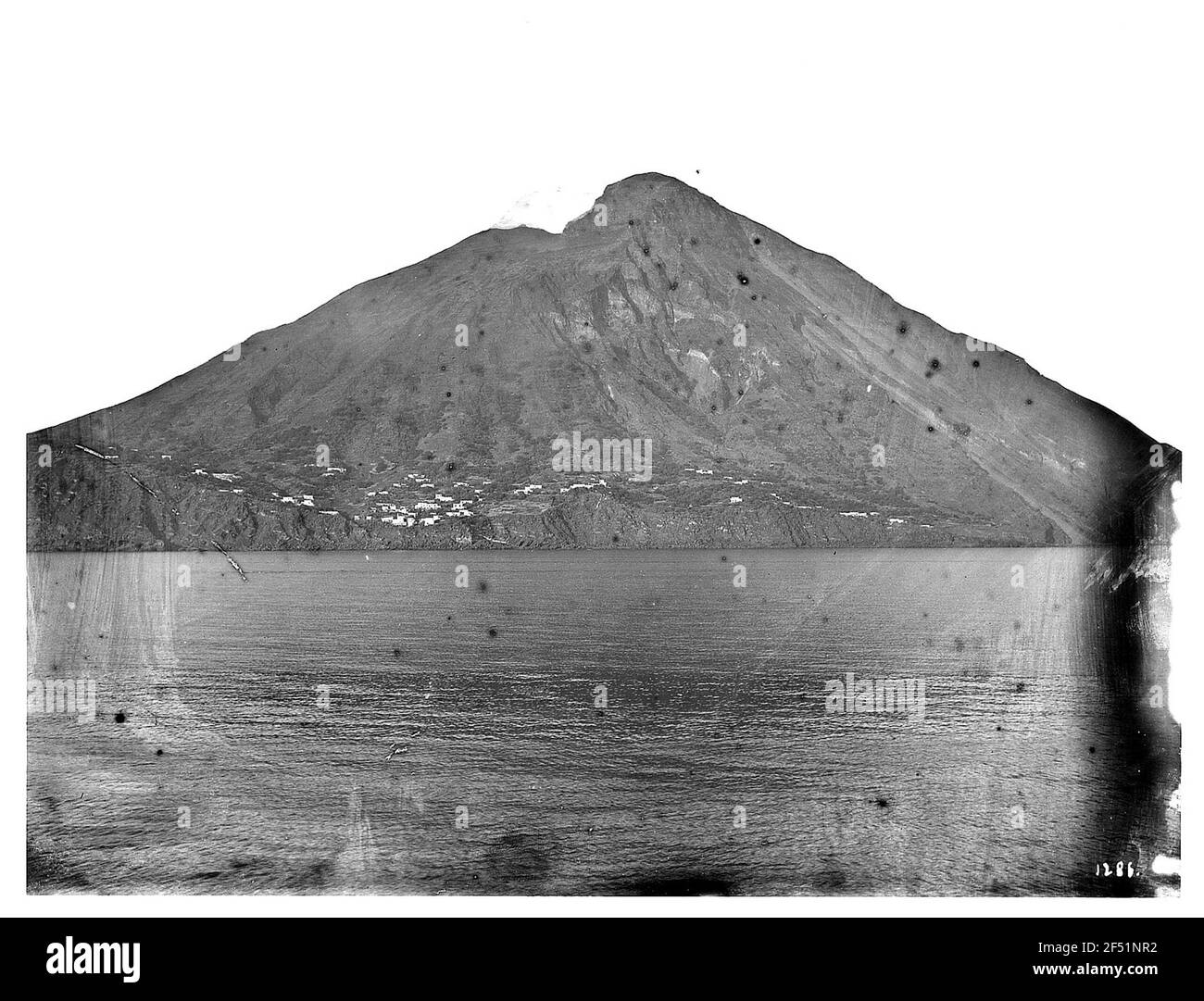 Stromboli, Italie. Vue de l'eau à l'île volcanique. Vue de bord d'un bateau à vapeur de passagers sur le volcan en forme de cône de l'île Stromboli avec les maisons de Ginostra Banque D'Images