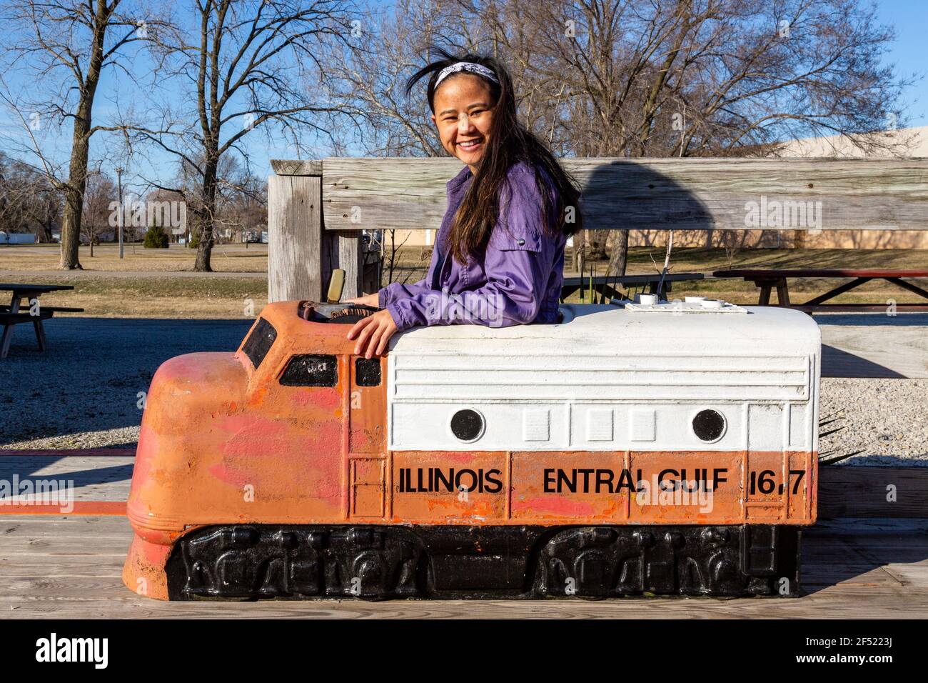 Une jeune femme souriante est assise dans une locomotive de chemin de fer du golfe central de l'Illinois au Hoosier Valley Railroad Museum à North Judson, Indiana, États-Unis. Banque D'Images