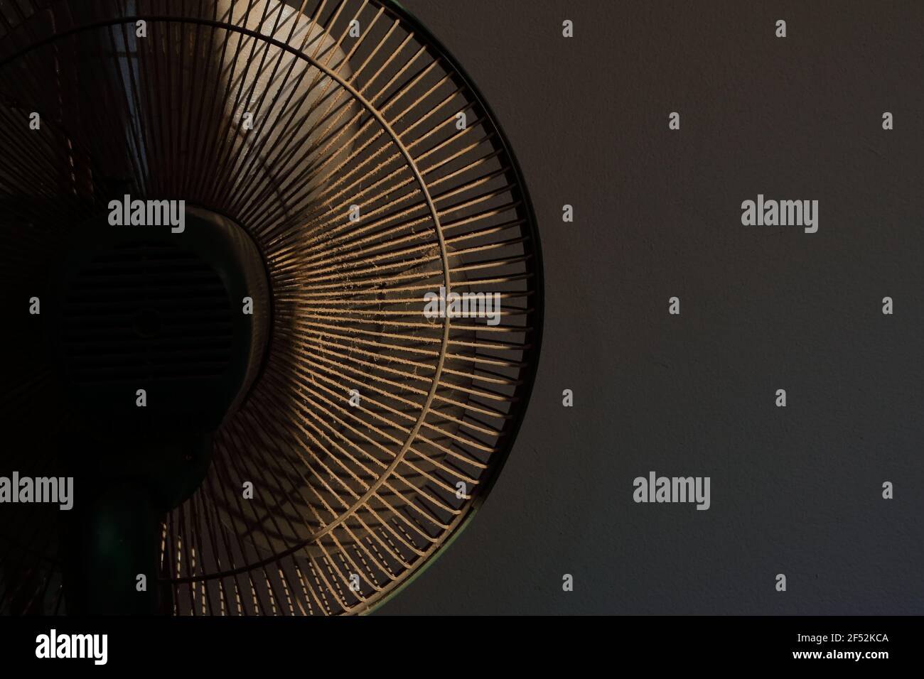 Fermer la partie arrière du capot du ventilateur électrique pleine de poussière dans la pièce contre le mur de ciment Banque D'Images