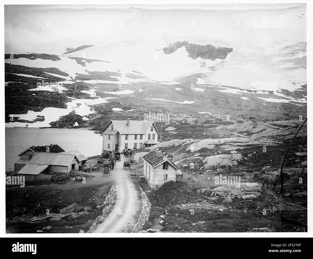 Norvège. Règlement sur le Djupwasssee. Regardez les maisons en bois sur la rive du lac au pied des montagnes enneigées Banque D'Images