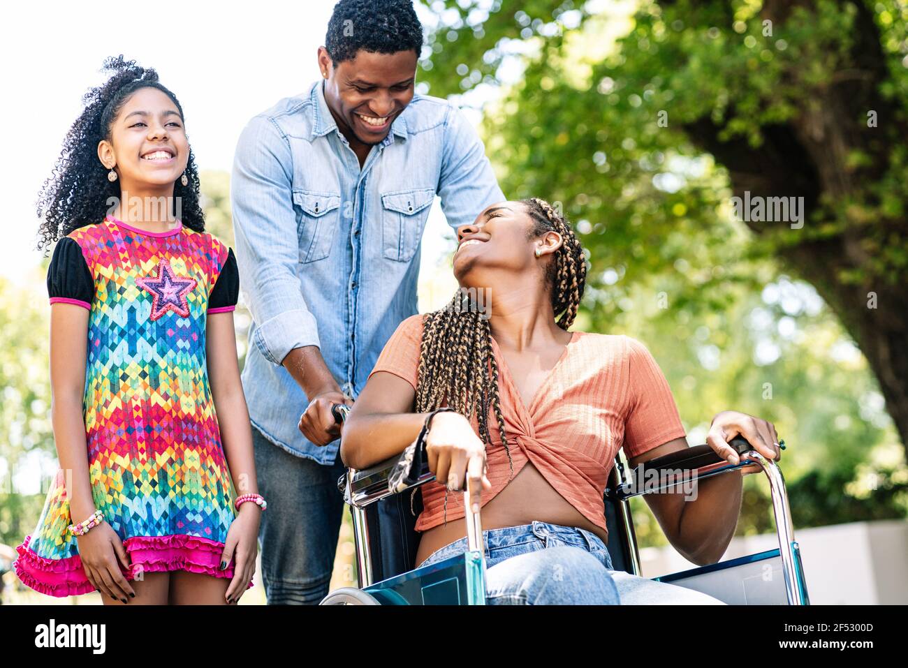 Femme en fauteuil roulant en train de faire une promenade en famille. Banque D'Images
