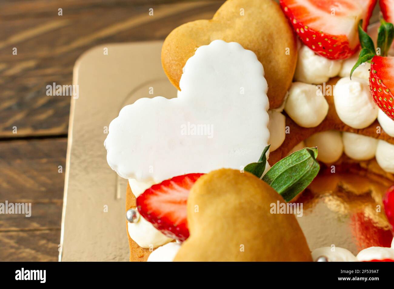 Génoise aux fraises, barres de chocolat au lait rose, asperges argentées, crème à la vanille et petits gâteaux à la cape en forme de coeur. Dessert sucré d'été pour bi Banque D'Images