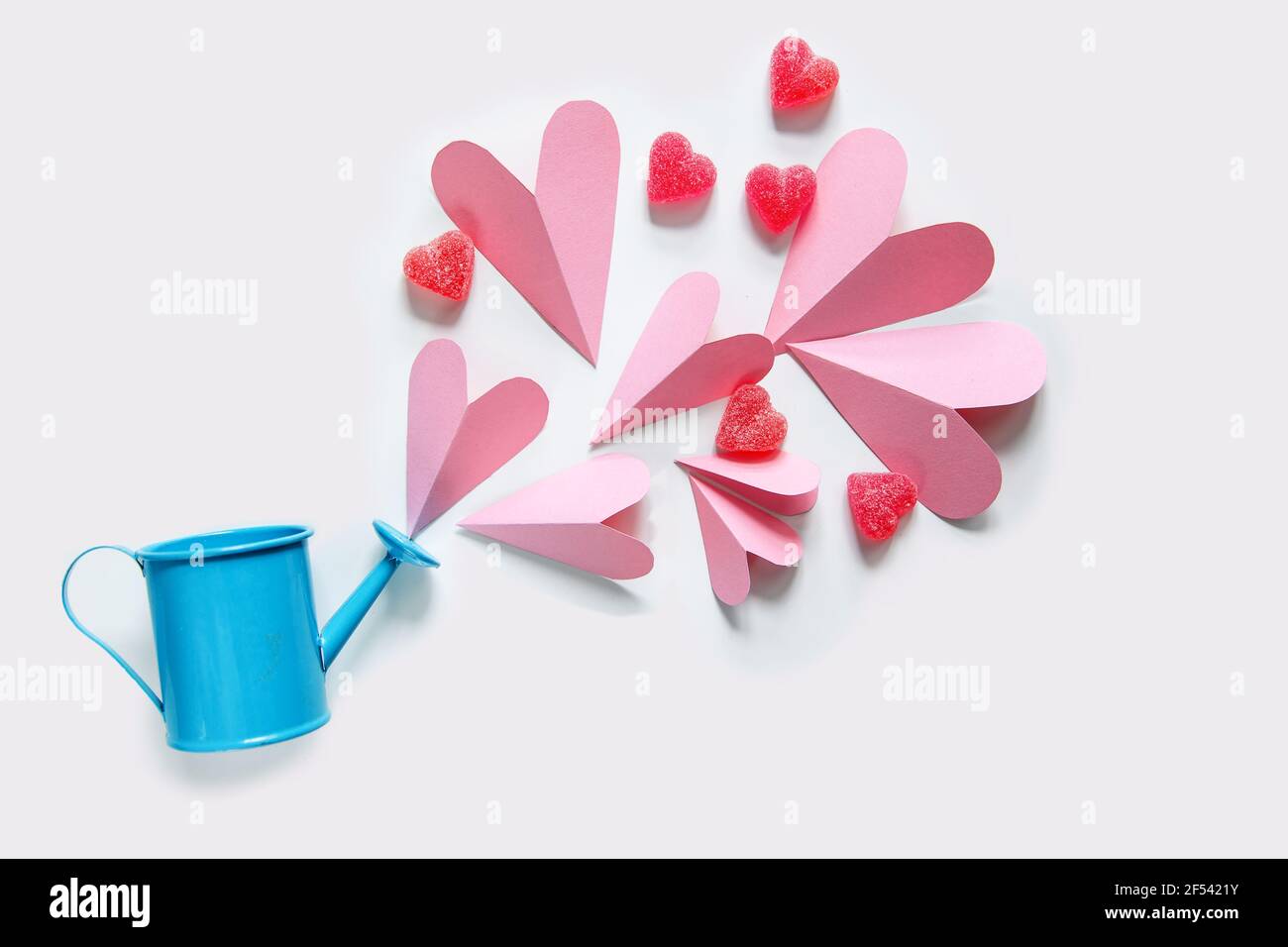 Des coeurs roses flottants sortent de l'arrosoir. Concept de la Saint-Valentin. Banque D'Images