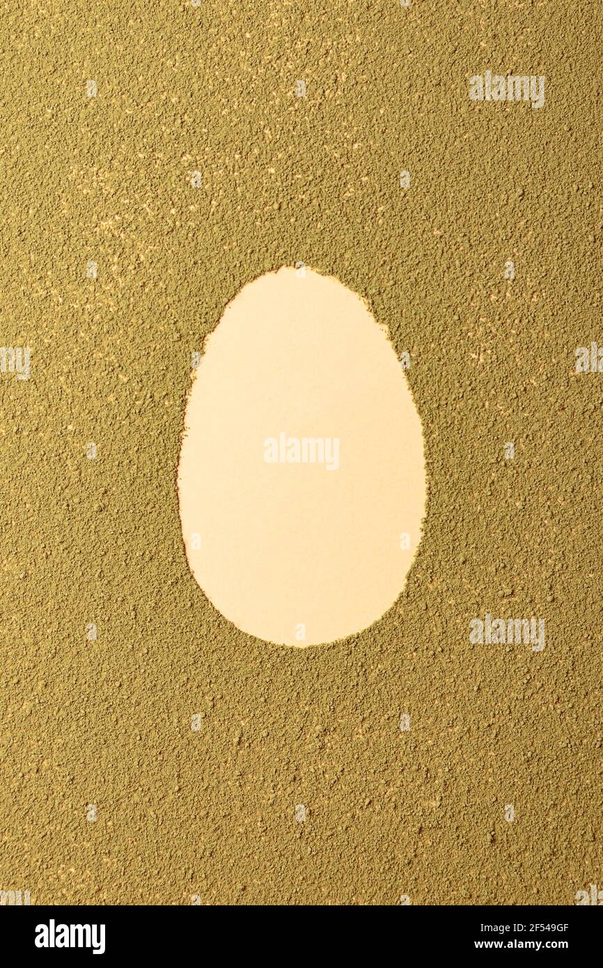 Silhouette ovale aux œufs de pâques faite à partir de thé matcha sur fond vert texturé. Minimalisme Banque D'Images