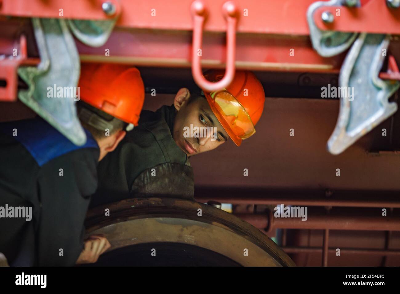 Ekibastuz, région de Pavlodar, Kazakhstan Mai 28 2012 : usine de construction automobile. Deux jeunes travailleurs sous la voiture. Banque D'Images