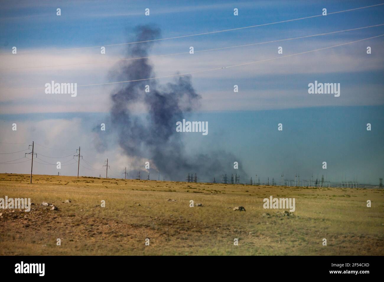 Vue panoramique sur la steppe et l'explosion. Carrière d'extraction de charbon au Kazakhstan. Fumée noire sur fond bleu ciel. Banque D'Images