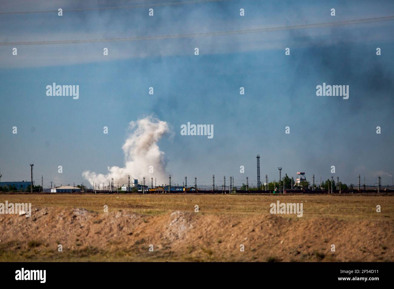 Vue panoramique sur la steppe et l'explosion. Nuage blanc et fumée noire. Carrière de charbon au Kazakhstan. Banque D'Images