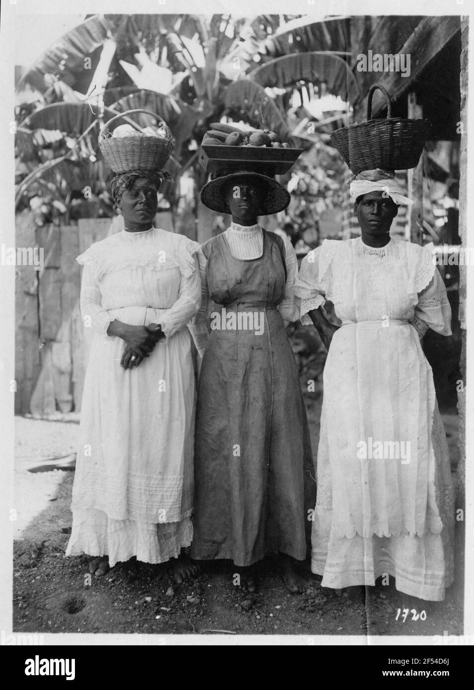 Saint-Pierre/Martinique. Porte-fruits. Trois femmes indigènes en longues jupes et volants blus posant avec des paniers de fruits sur la tête Banque D'Images