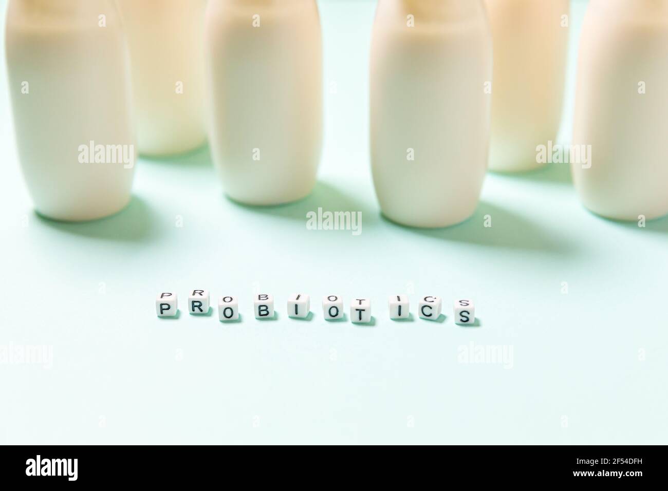 Petits flacons avec probiotiques et prébiotiques boisson laitière sur fond bleu. Production avec des additifs biologiquement actifs. Fermentation et régime guérir Banque D'Images