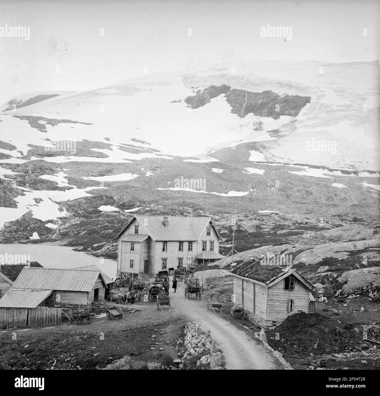 Norvège. Règlement sur le Djupwasssee. Regardez les maisons en bois sur la rive du lac au pied des montagnes enneigées Banque D'Images