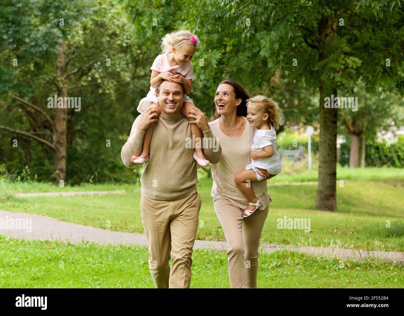 Portrait of happy parents transportant des enfants dans le parc Banque D'Images
