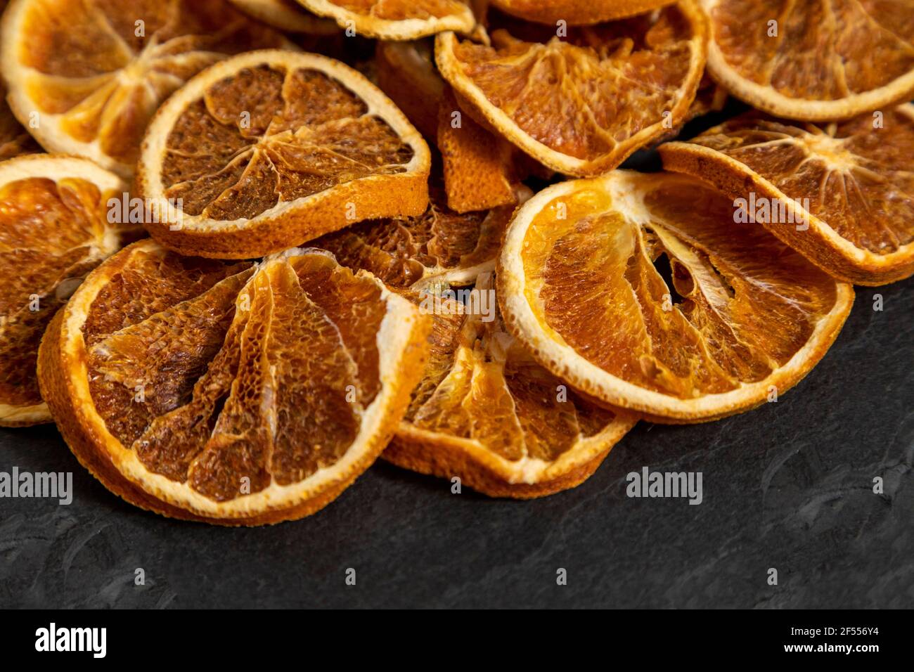 Tranches d'orange déshydratée sur pierre noire. Mise au point sélective. Banque D'Images