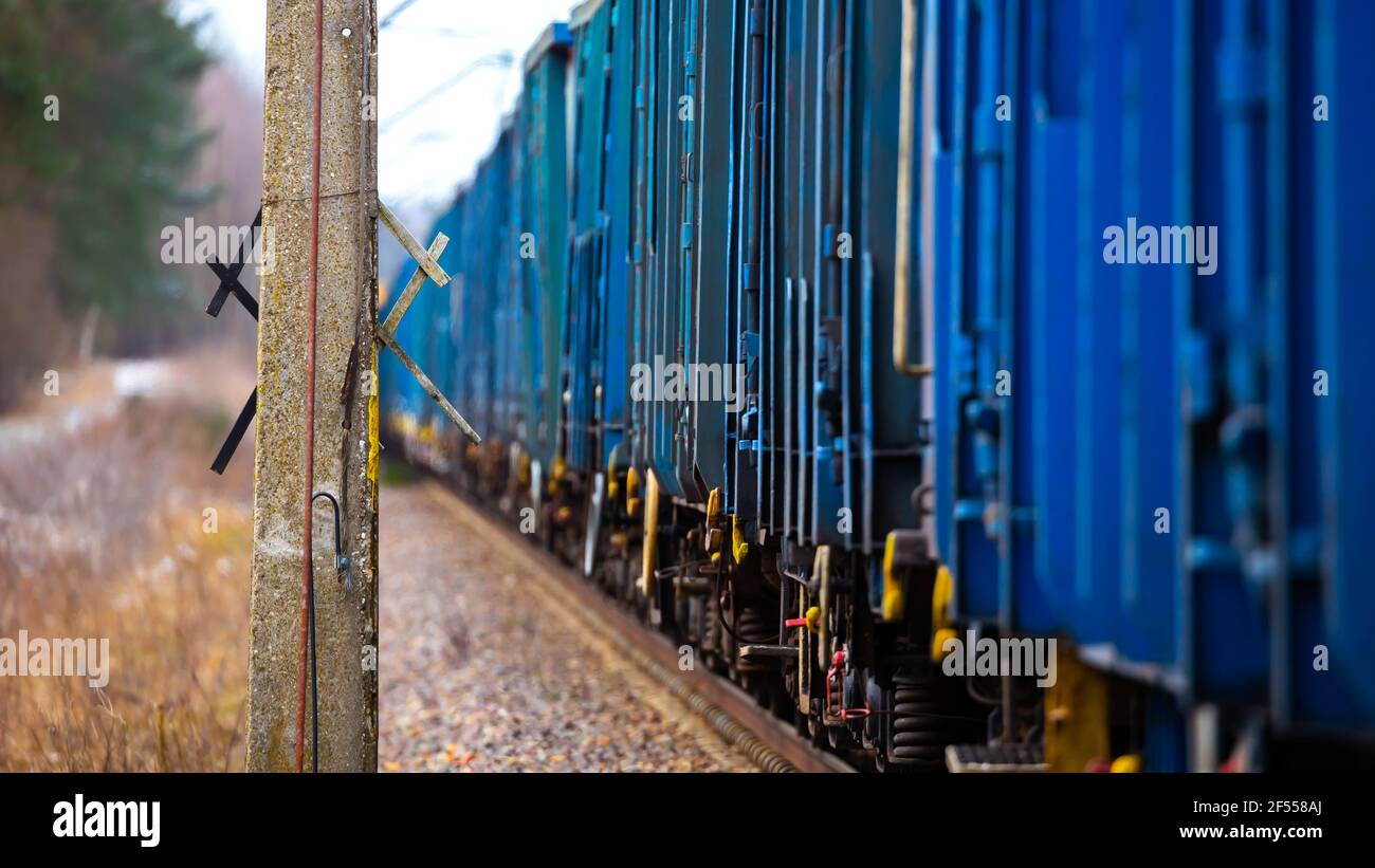 Vue en perspective d'un train de marchandises de passage. Photo prise dans des conditions de faible luminosité. Banque D'Images
