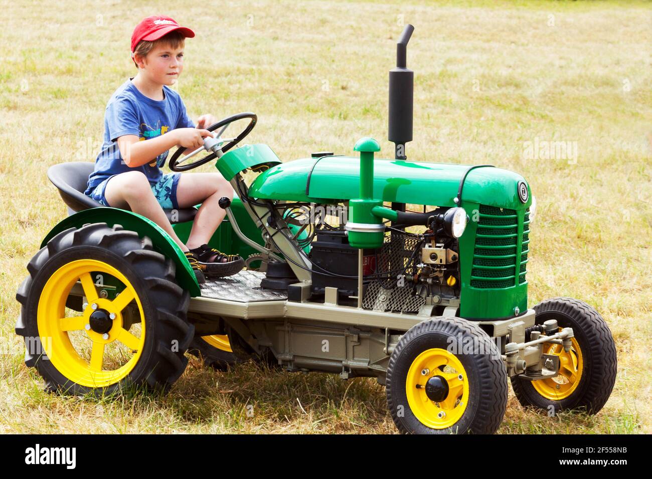 Petit Garçon Dans Des Bottes De Caoutchouc Tire Un Tracteur De Voitures De  Jouets De Jouet Sur Une Corde Photo stock - Image du regroupement, petit:  184264624