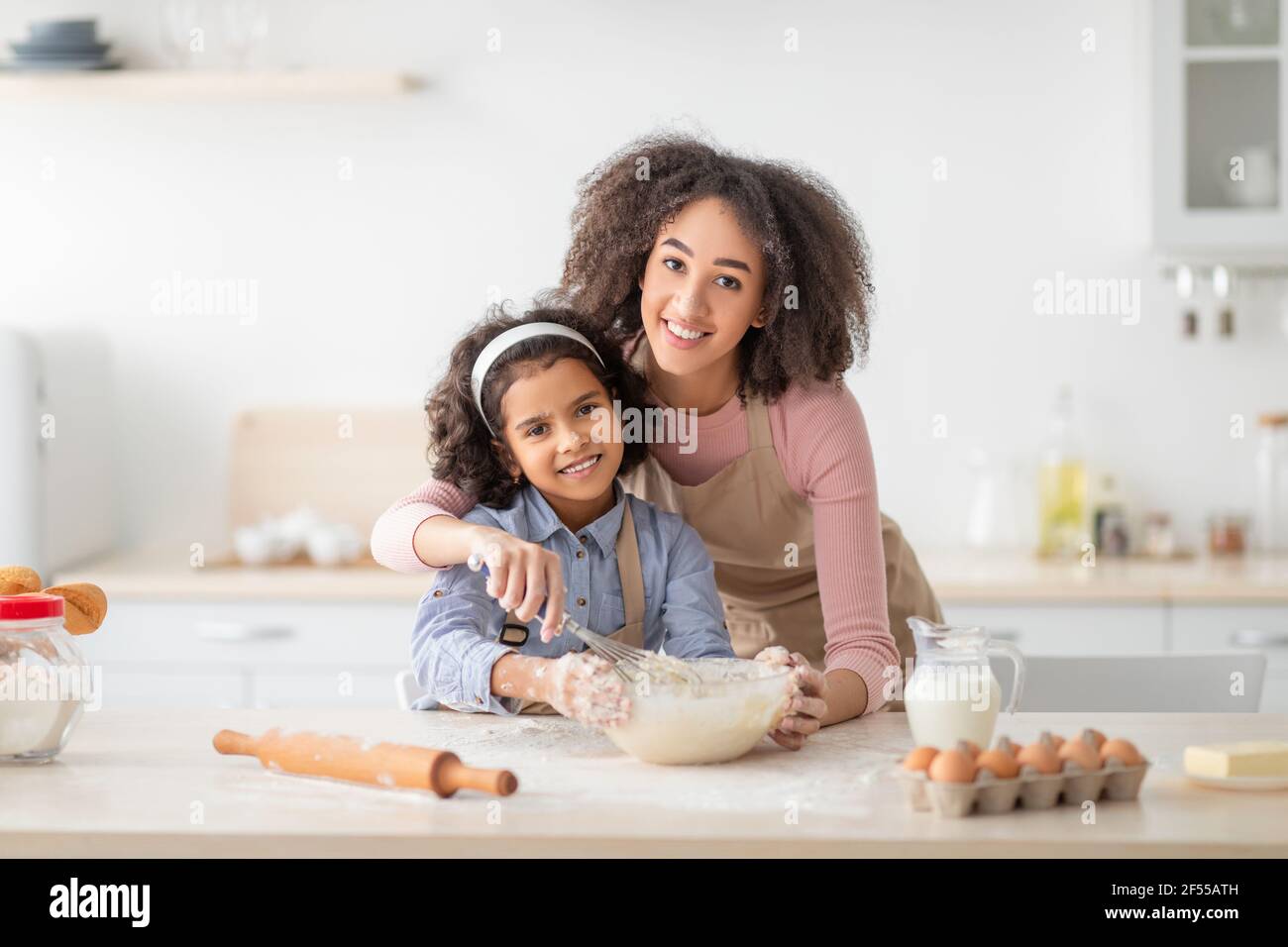 Positif noir femme et fille pétrissage de la pâte dans la cuisine moderne Banque D'Images