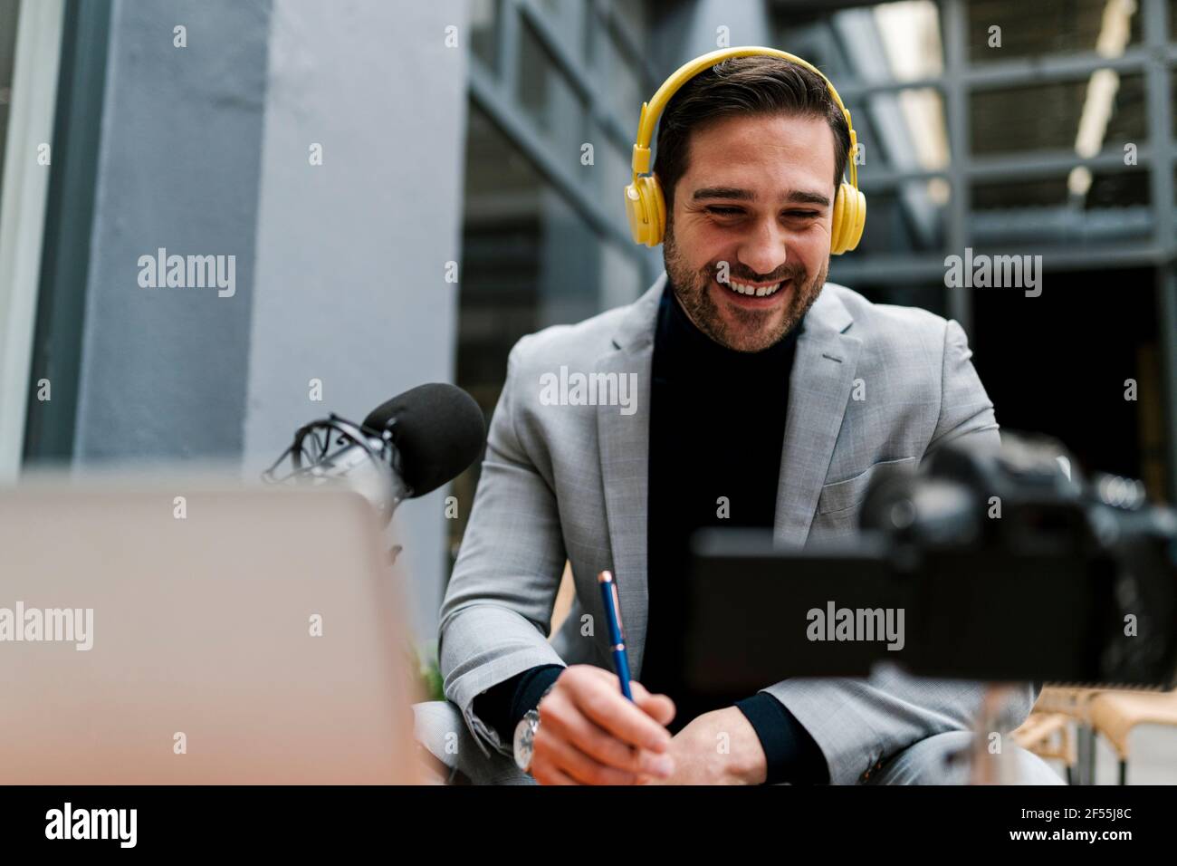 Homme d'affaires souriant qui se vante à travers l'appareil photo tout en étant assis dans un café Banque D'Images