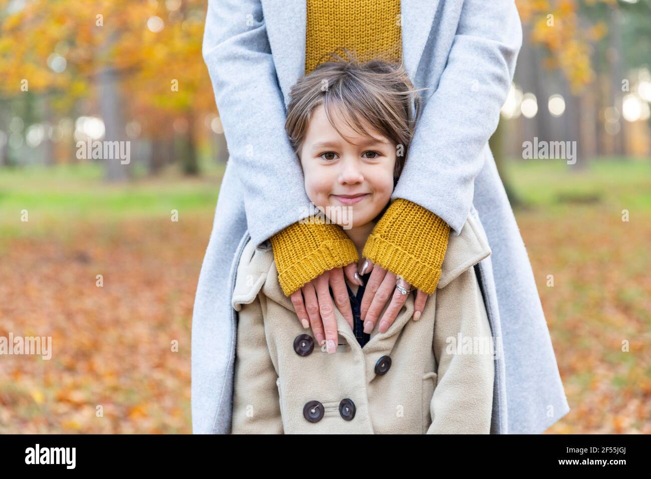 Fille souriante en se tenant debout avec une femme en forêt Banque D'Images