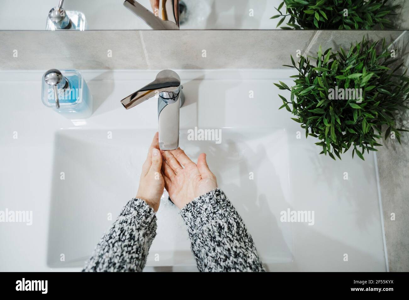 Femme se lavant les mains à chanter dans la salle de bains Banque D'Images