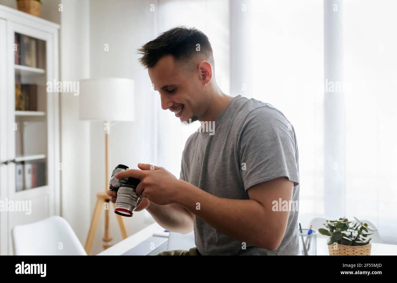 Homme souriant entrepreneur tenant la caméra au bureau à domicile Banque D'Images