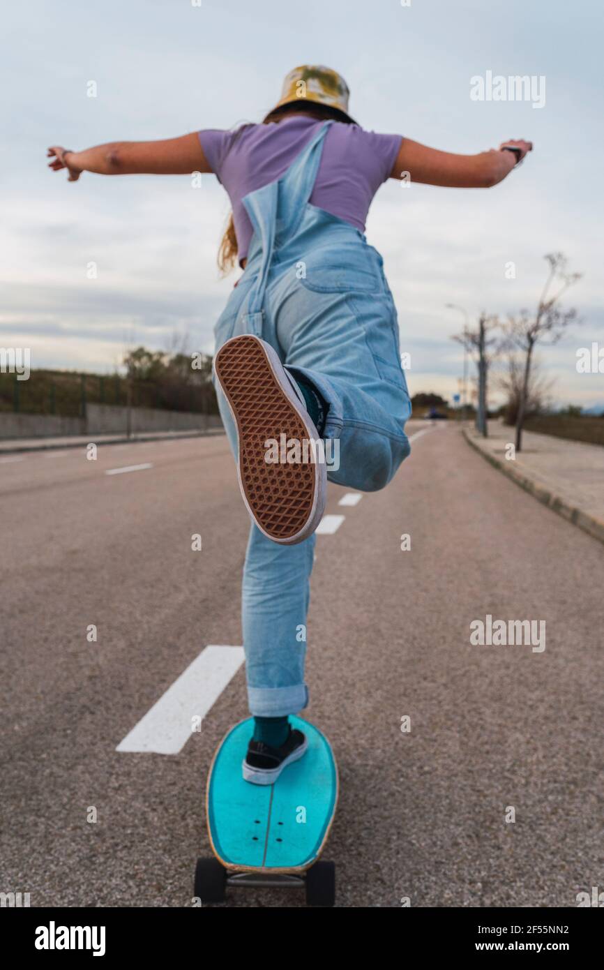 Jeune femme patinant sur la route Banque D'Images