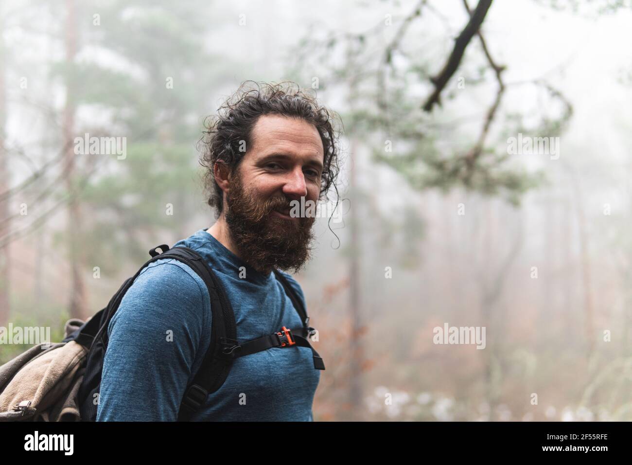 Portrait d'un randonneur barbu souriant à l'appareil photo Banque D'Images