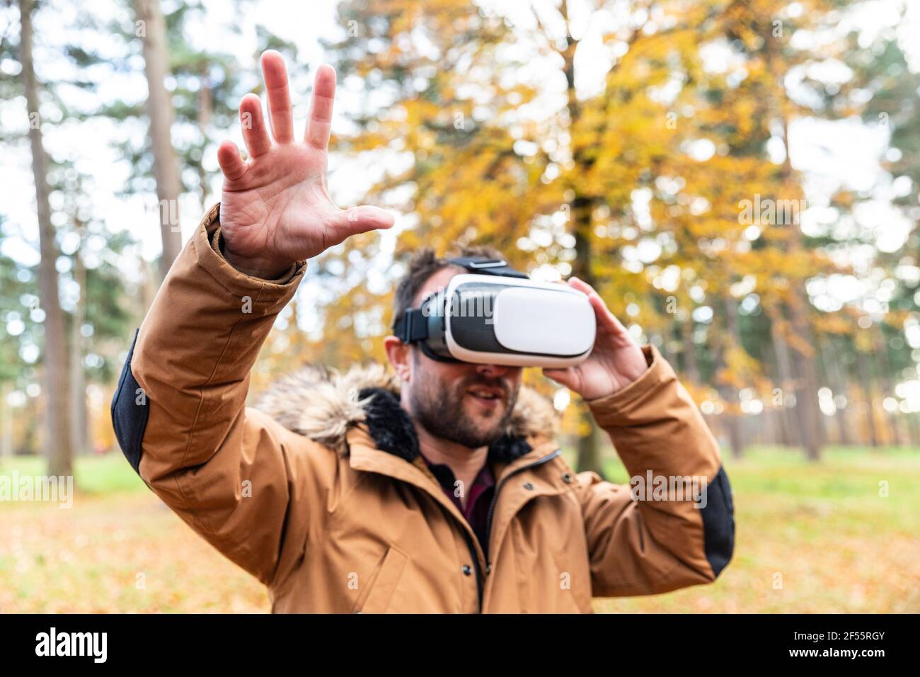 Homme mature utilisant un simulateur de réalité virtuelle en forêt Banque D'Images