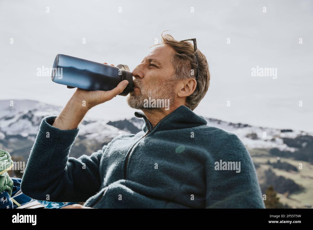 Homme mature buvant de l'eau contre le ciel à Salzburger Land, Autriche Banque D'Images