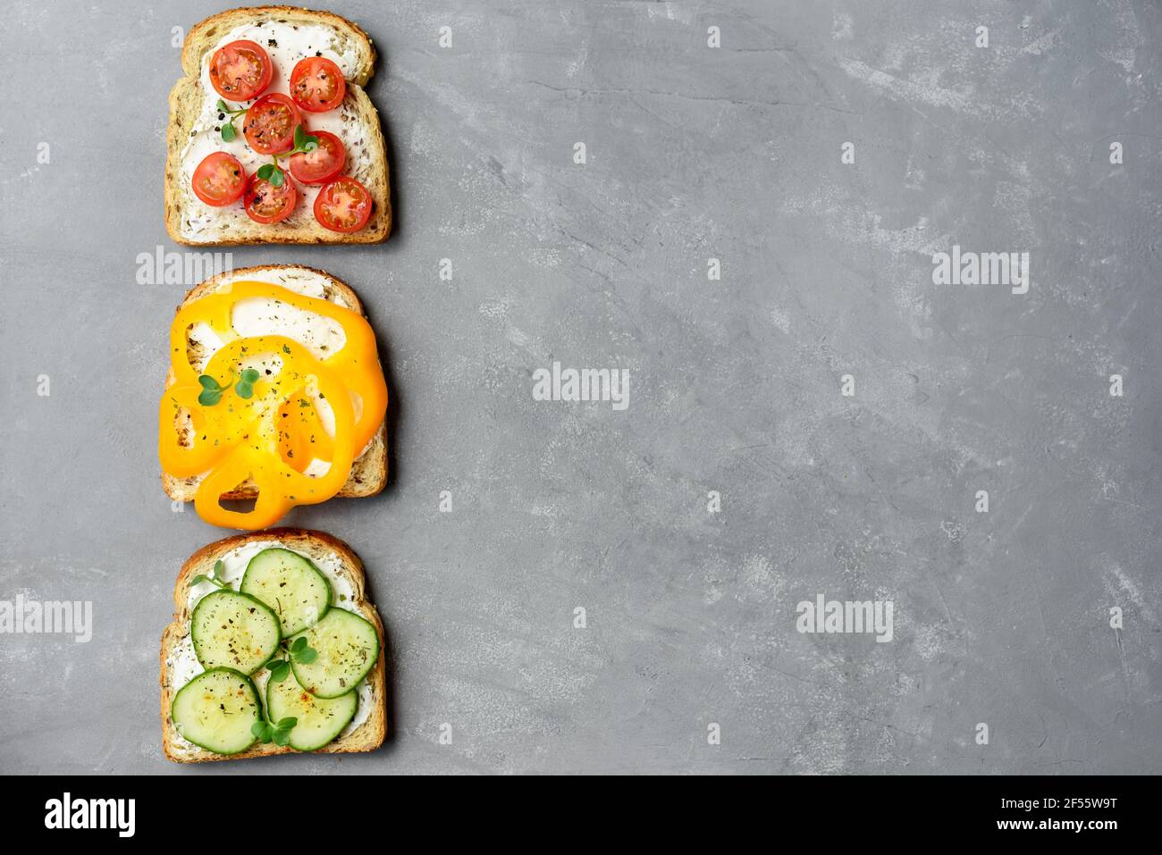 Sandwiches végétariens sains avec légumes - poivre jaune, tomate, concombre et radis. Fromage à la crème et micro-légumes Banque D'Images