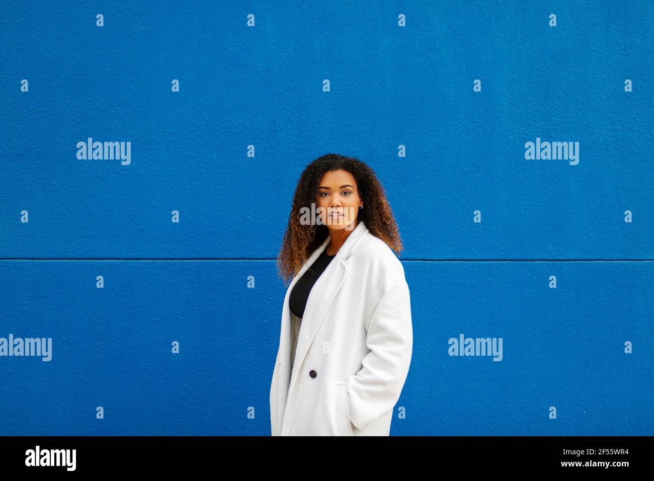 Jeune femme portant une couche de finition contre le mur Photo Stock - Alamy