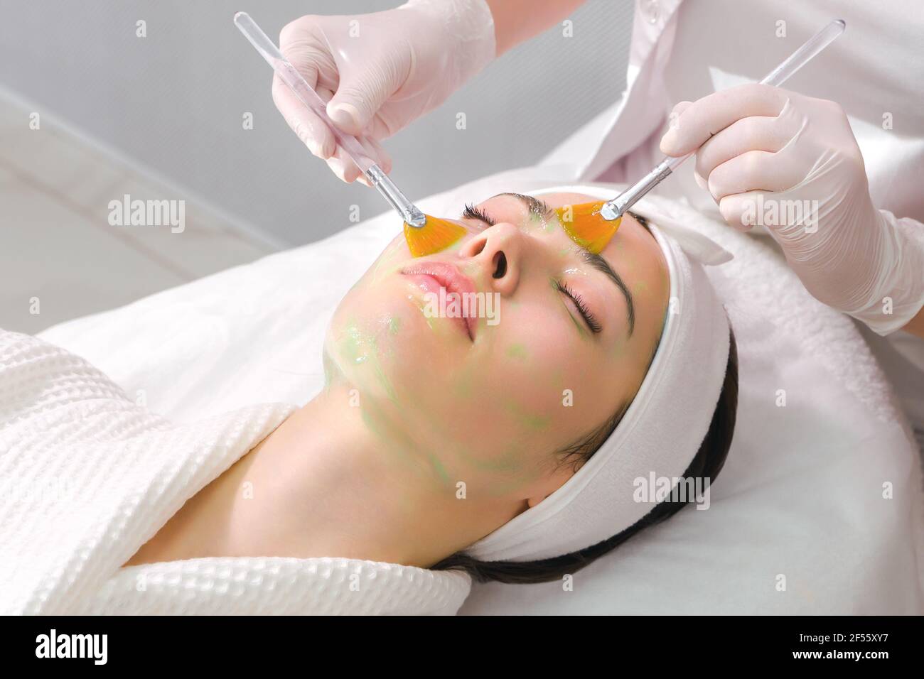 Soin du visage. Un masque est appliqué à un visage de femme dans une clinique de cosmétologie. Gros plan Banque D'Images