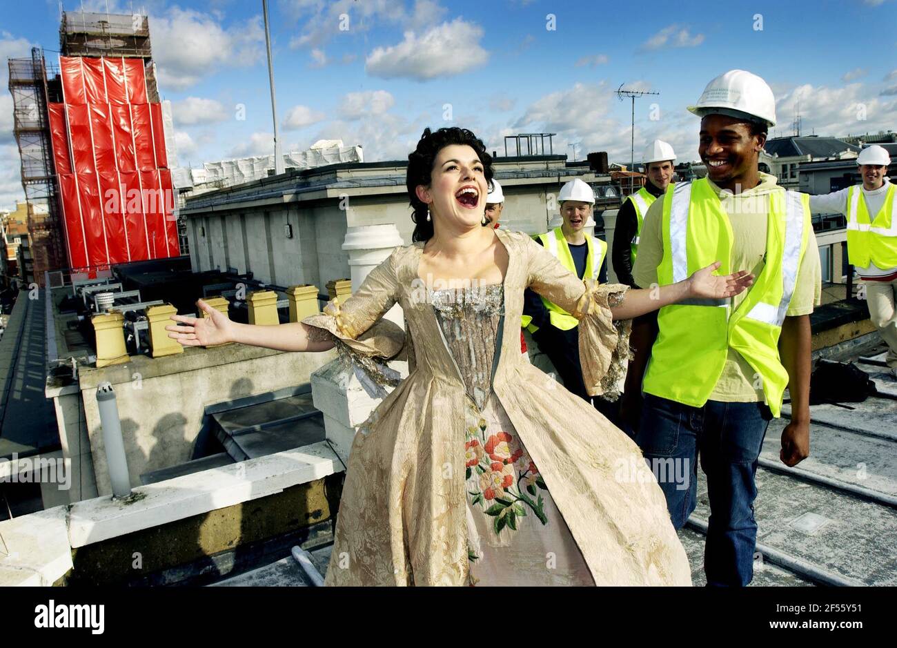 Victoria Simmonds, qui chantera le rôle principal de Rosina dans la renaissance d'ENO de 'le Barbier de Séville', posant avec des ouvriers de construction sur le toit de la place No 6 St Martins avec les travaux de construction en cours du Colisée en arrière-plan. Ce stunt a été en faveur de la promotion du lancement de la saison ENO 2002/3 au London Coliseum qui ouvre le jeudi 24 octobre.23 octobre 2002 photo Andy Paradise Banque D'Images