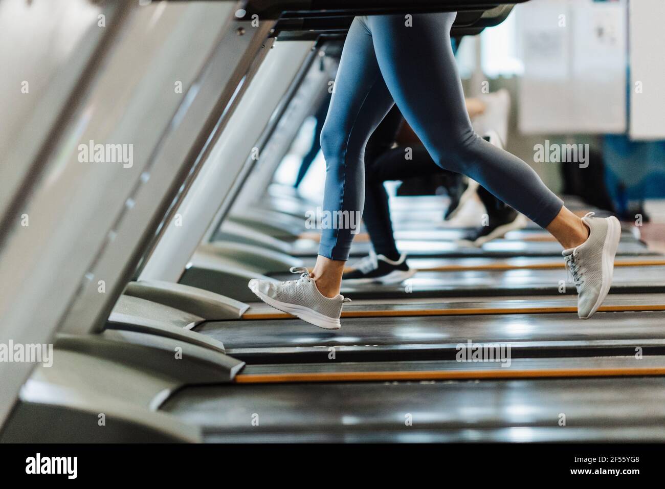 Un athlète masculin et féminin s'entraînant sur un tapis roulant dans la  salle de gym Photo Stock - Alamy