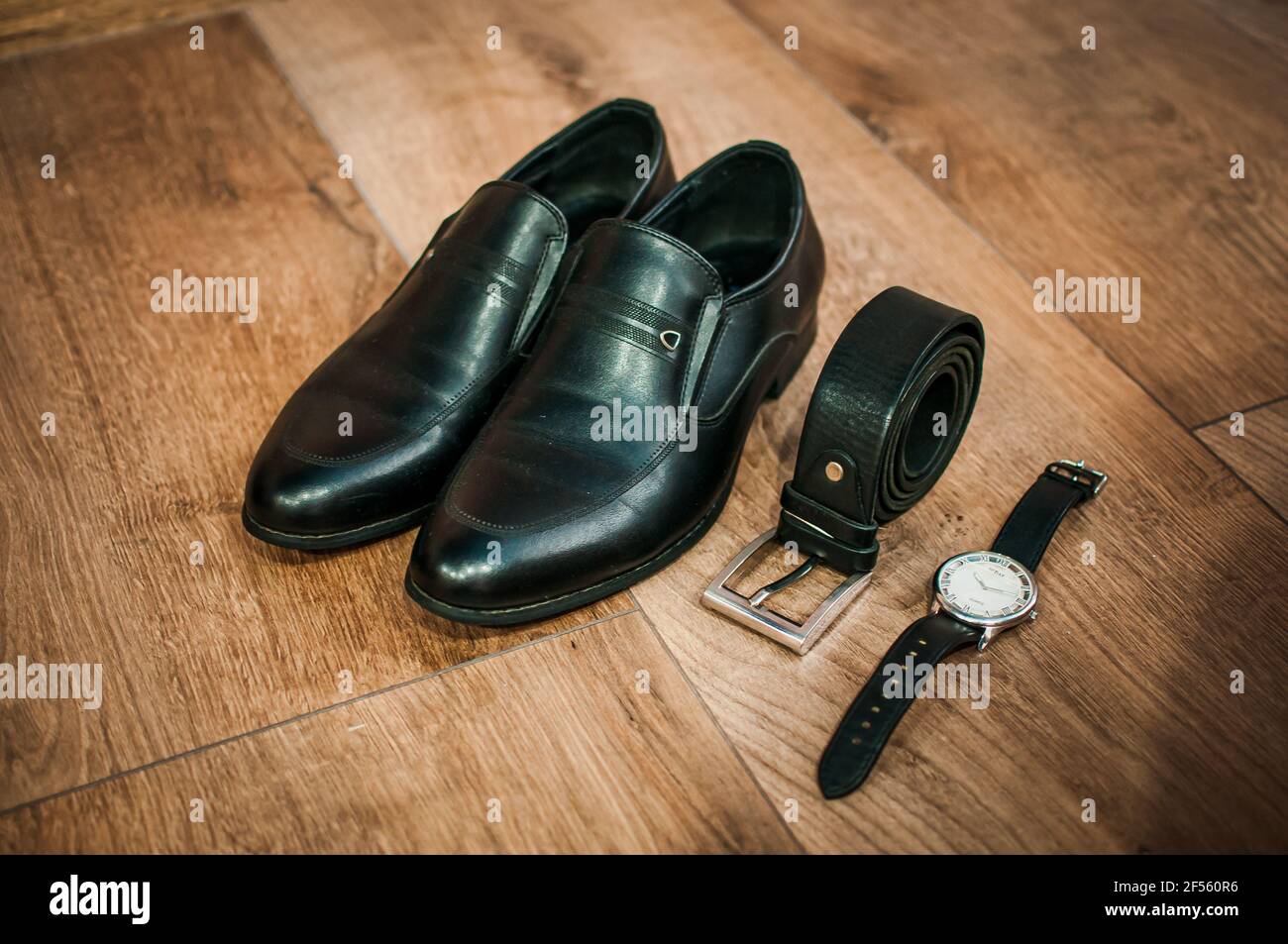 Des chaussures en cuir noir pour hommes, une montre et une ceinture se  trouvent sur le sol. Accessoires pour marié Photo Stock - Alamy