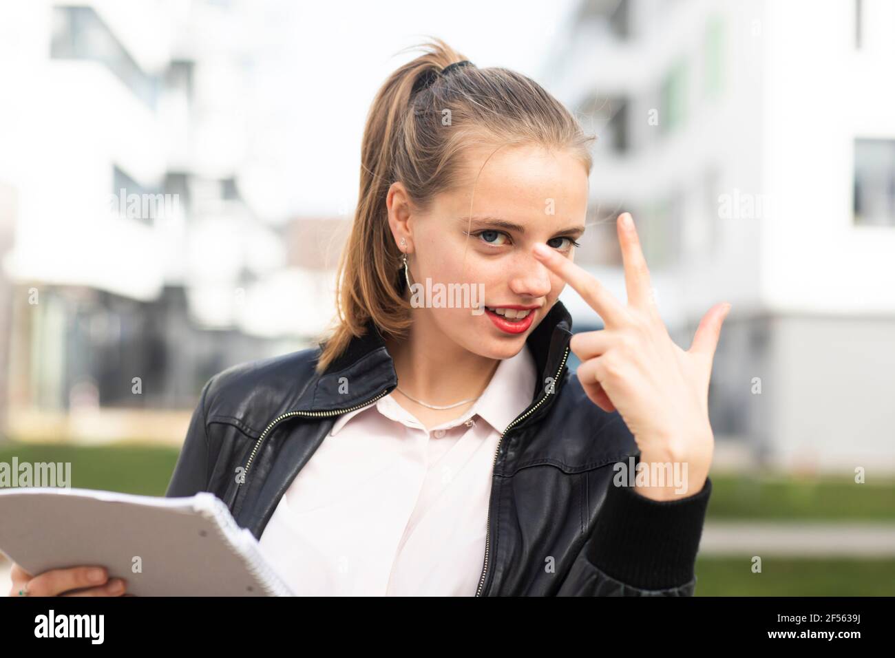 Portrait d'une jeune femme blonde montrant trois doigts Banque D'Images