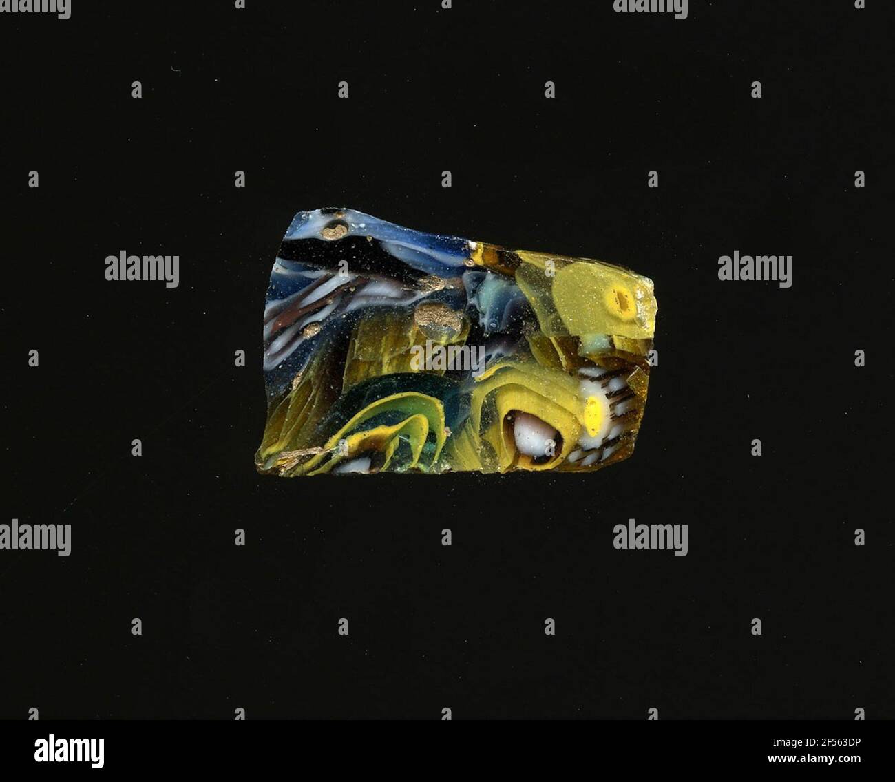 Fragment d'un vaisseau. Une faible courbure du fragment de verre permet l'affectation à un vaisseau. Le verre violet est décoré avec deux types de fleurs dans la technologie millefiori et des bandes dans différentes couleurs. Les fleurs sont soit faites d'un noyau blanc avec un contour transparent pour s'étendre sur une spirale jaune sur un fond bleu, ou d'un point jaune avec un contour blanc pour spécifier les points blancs les pétales. Pour la production de verres de différentes couleurs aux tubes et barres en forme. Elles étaient comprimées et chauffées, ce qui entraînait une longue barre. Le verre tranché ​​now avait différents pattes amorphes ou floraux Banque D'Images