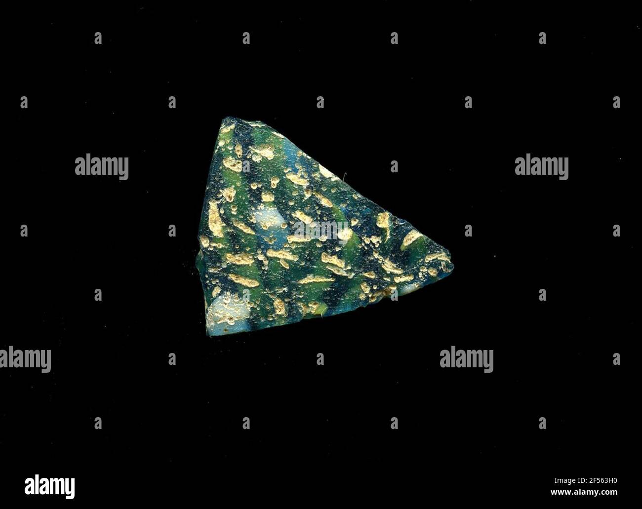 Fragment d'un vaisseau. Une faible courbure du fragment de verre permet l'affectation à un vaisseau, éventuellement à une coque. Le shard bleu orne un petit motif de pois blancs et jaunes. Pour la production, des verres de différentes couleurs ont été formés en tubes et en tiges. Elles étaient comprimées et chauffées, ce qui entraînait une longue barre. Le verre coupé en tranches de ​​now avait des motifs amorphes ou floraux différents. Par la suite, plusieurs de ces plaquettes ont été repliées ensemble, réchauffées à nouveau et pressées en forme vasculaire. Burry pour le processus de fabrication élaboré et sa fragilité a été l'un des articles de luxe de ant Banque D'Images