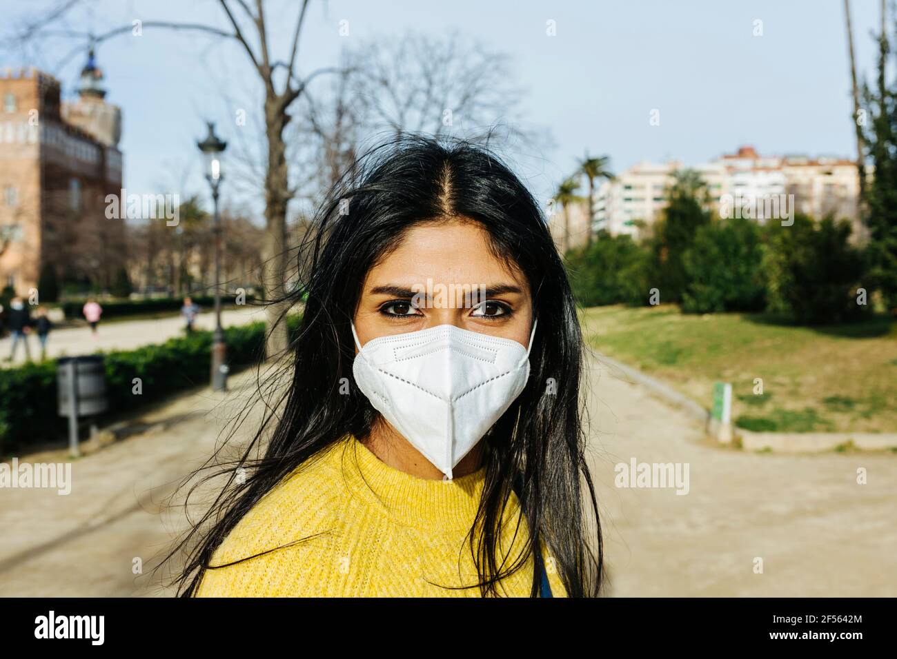 Femme avec masque de protection au parc public pendant COVID-19 Banque D'Images