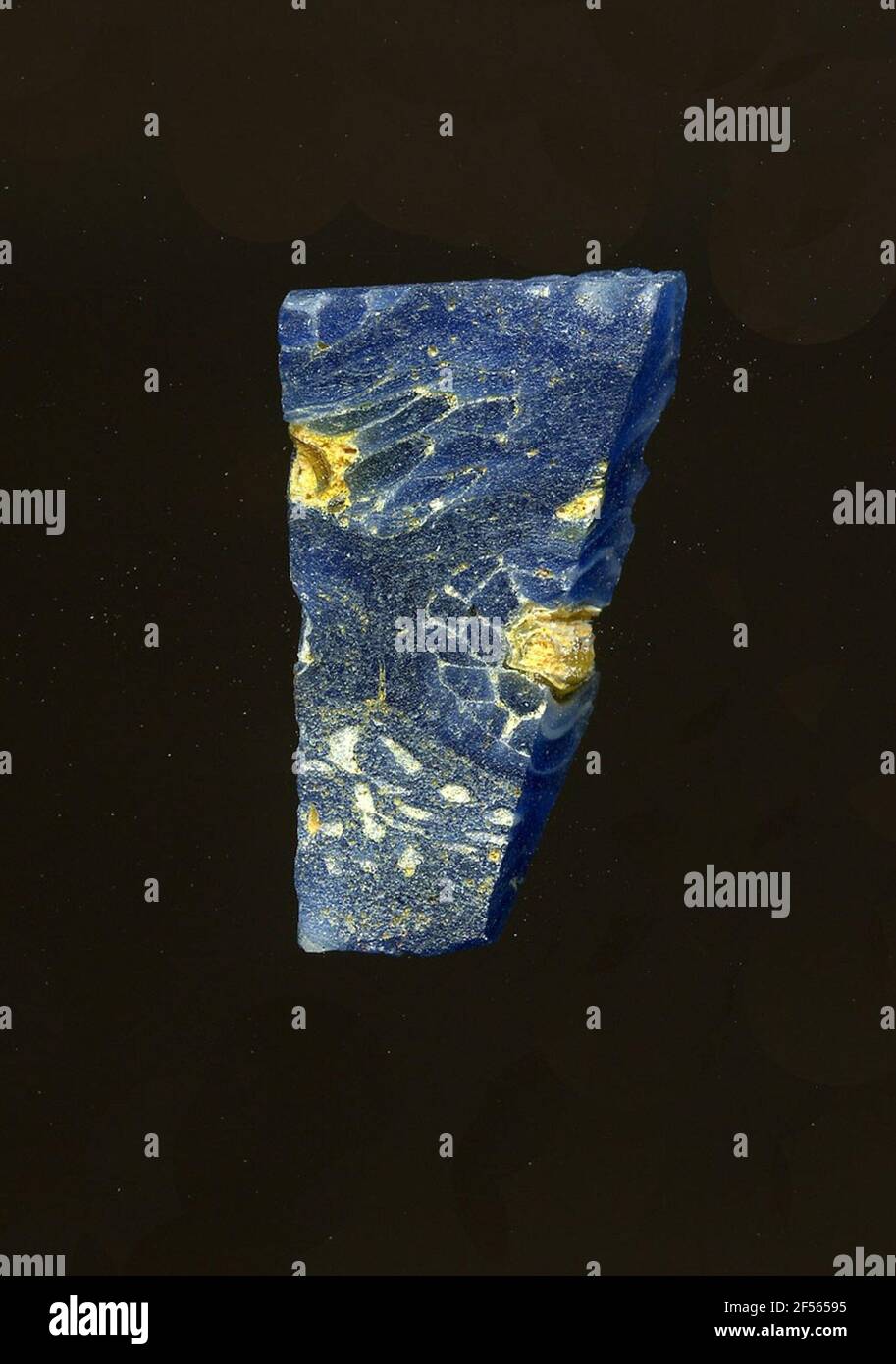 Fragment d'un vaisseau. Une faible courbure du fragment de verre permet l'affectation à un vaisseau. Sur fond bleu, on peut voir des fleurs dans la technologie millefiori. Ils se composent d'un point jaune pour spécifier les contours blancs des pétales. Pour la production, des verres de différentes couleurs ont été formés en tubes et en tiges. Elles étaient comprimées et chauffées, ce qui entraînait une longue barre. Le verre coupé en tranches de ​​now avait des motifs amorphes ou floraux différents. Par la suite, plusieurs de ces plaquettes ont été pliées, chauffées à nouveau et pressées en forme vasculaire. Burry pour le processus de fabrication élaboré et sa fragilité Banque D'Images