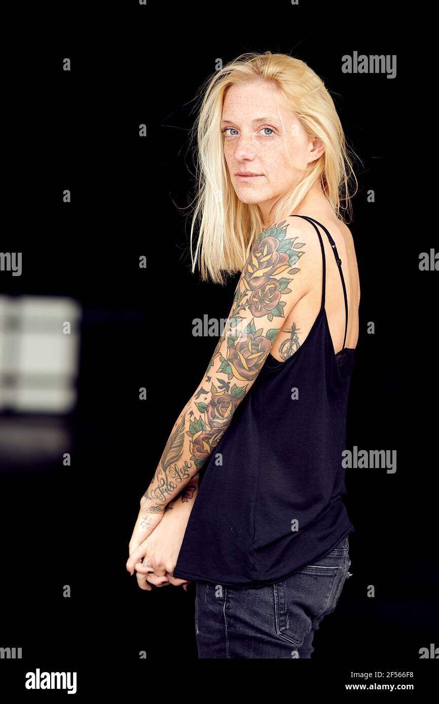 Femme tatouée avec les mains jointes au garage de stationnement Banque D'Images