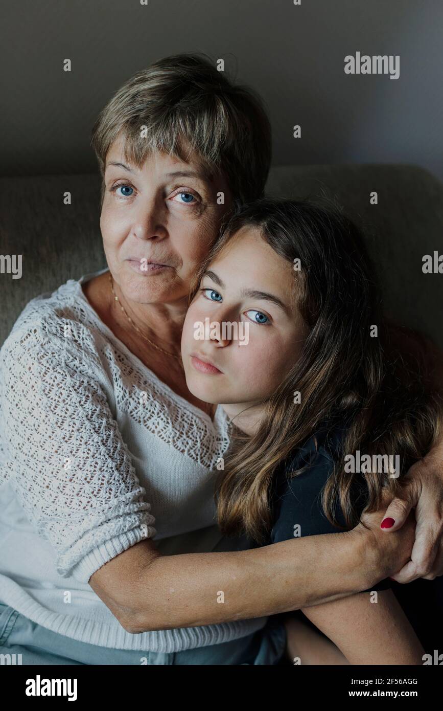 Grand-mère avec le bras autour de la petite-fille embrassant Banque D'Images
