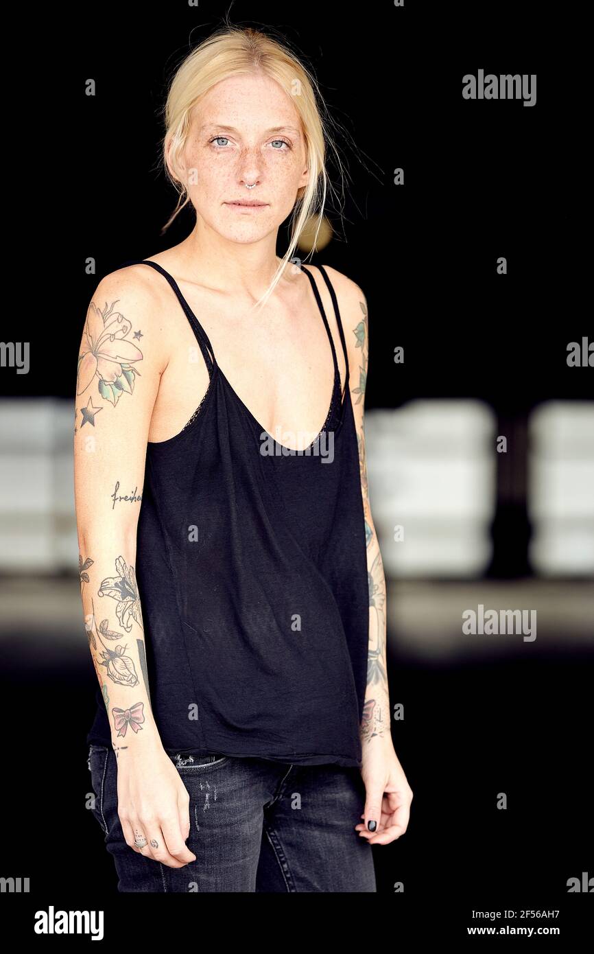 Jeune femme avec tatouage debout au garage de stationnement Banque D'Images