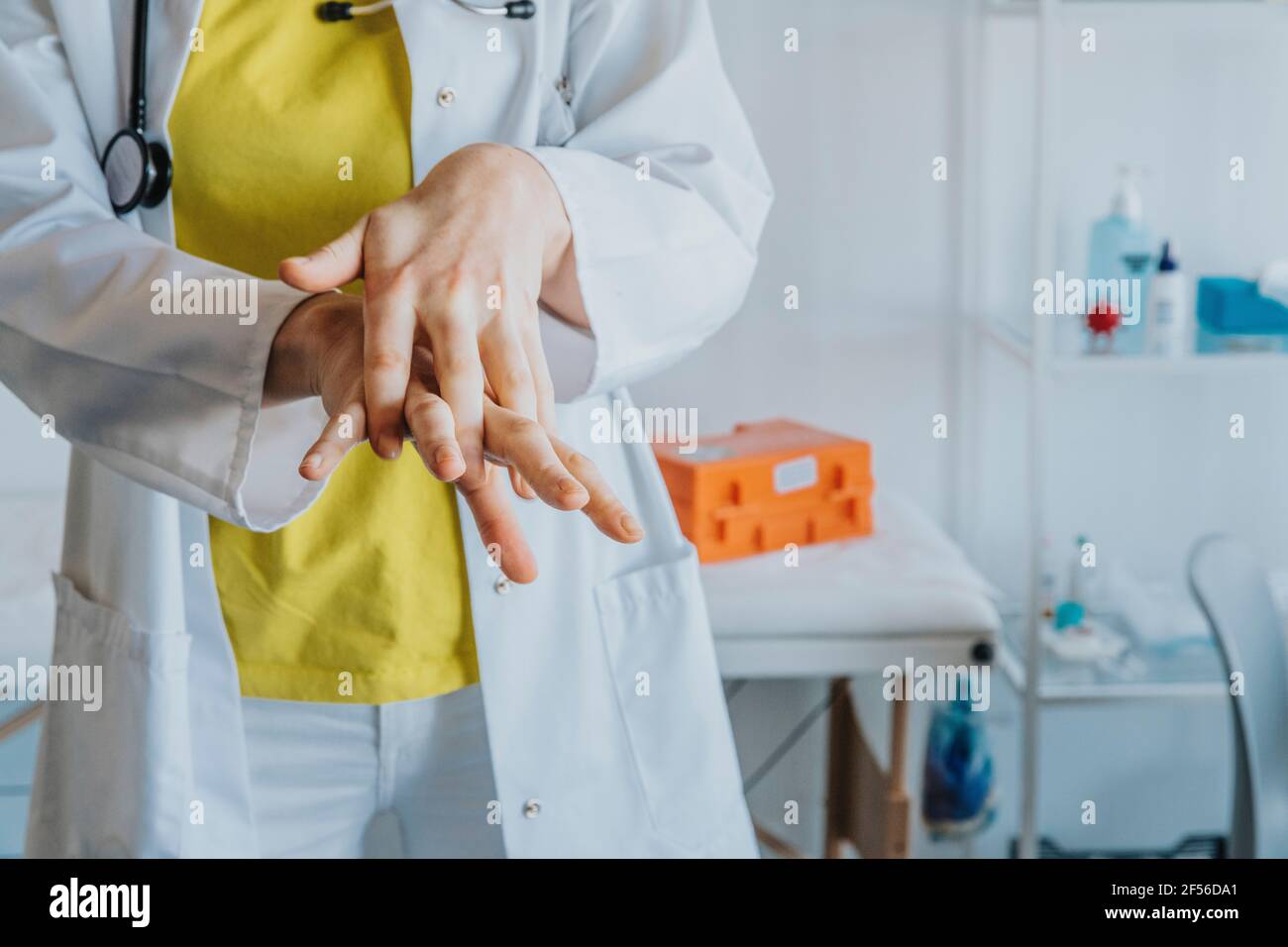 Une femme médecin se frottant les mains avec de l'assainisseur en se tenant à la clinique Banque D'Images