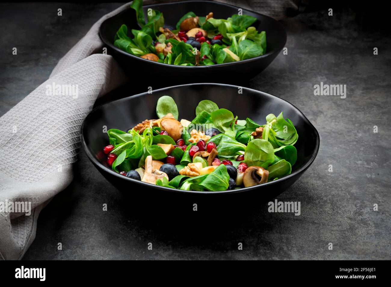 Salade d'automne composée d'agneaux, de laitue, de champignons, de poires frites, de bleuets, de graines de grenade et de noix Banque D'Images