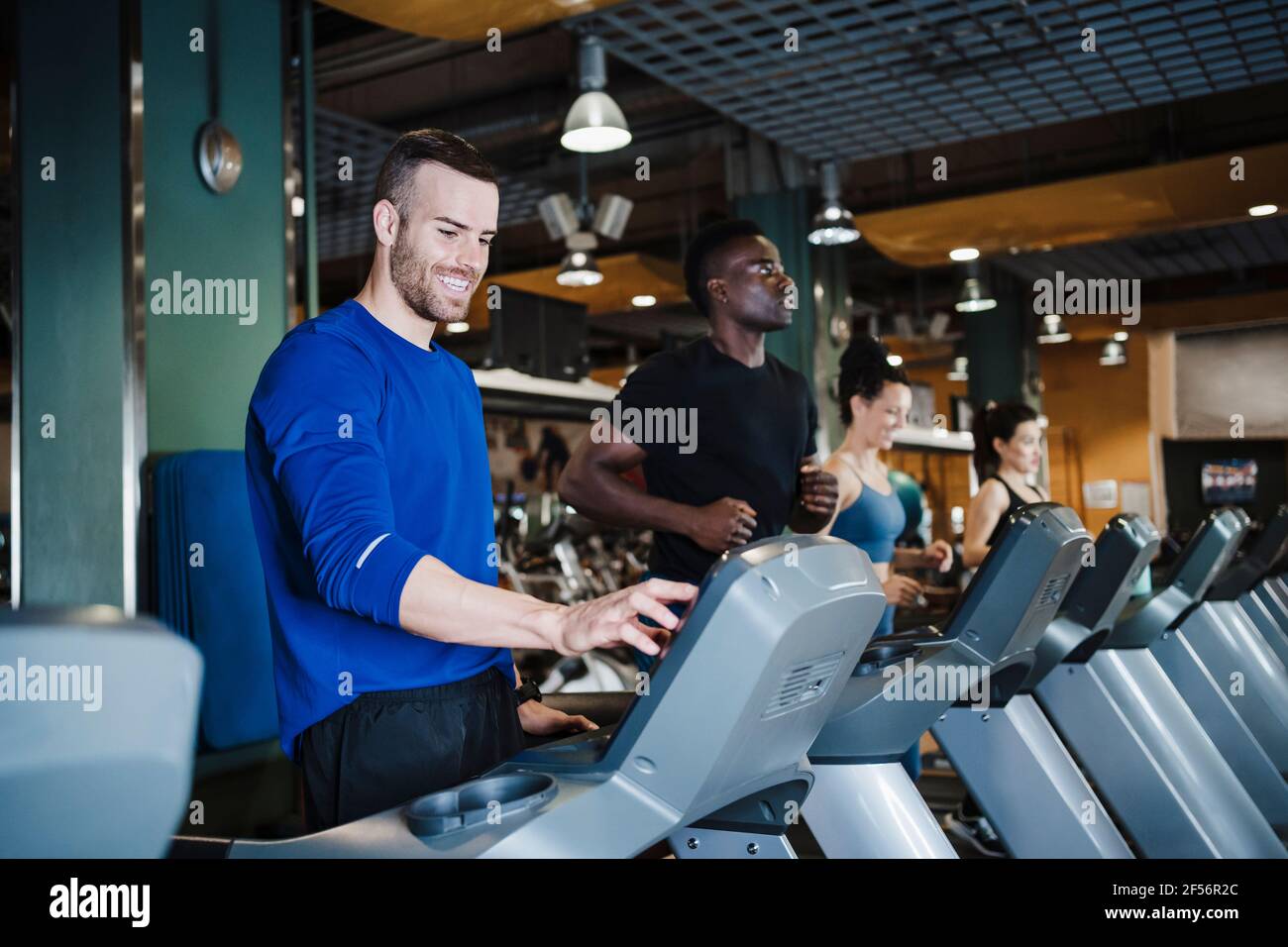 Hommes et femmes sportifs personnes courant sur tapis roulant en santé club Banque D'Images