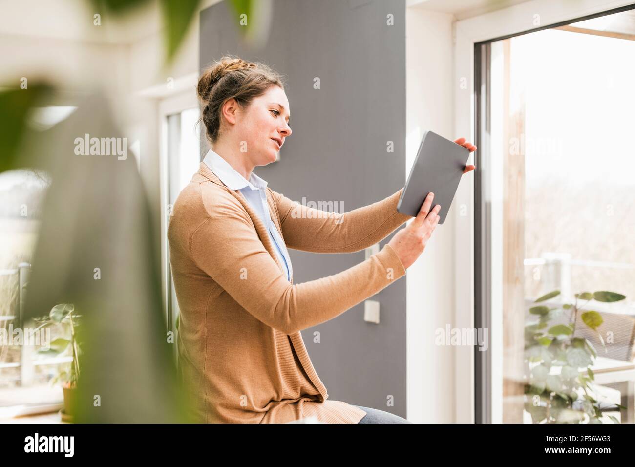 Une femme professionnelle qui parle en vidéo via une tablette à accueil Banque D'Images