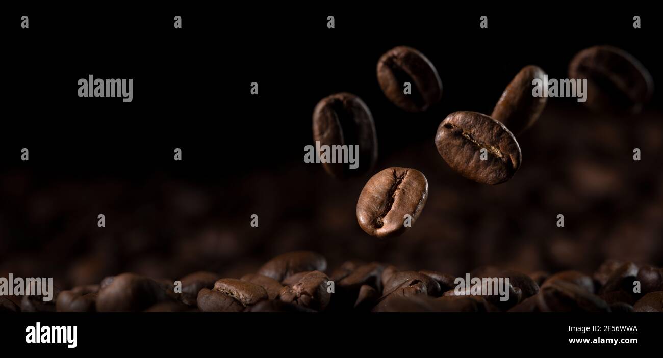 Gros plan, grains de café frais tombant sur le sol Banque D'Images