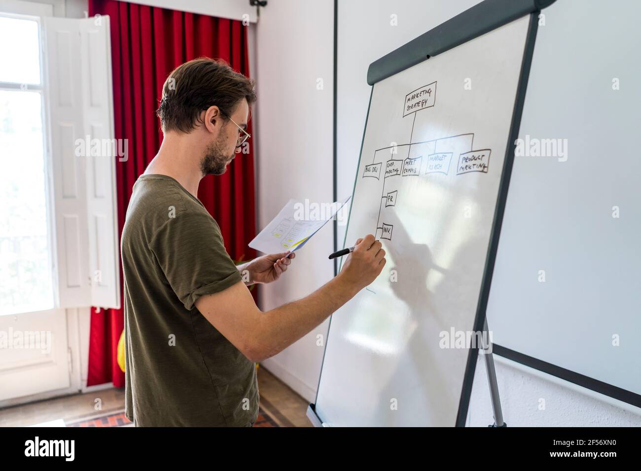 Schéma de dessin de l'entrepreneur masculin sur le tableau de conférence dans la salle de conseil à bureau Banque D'Images