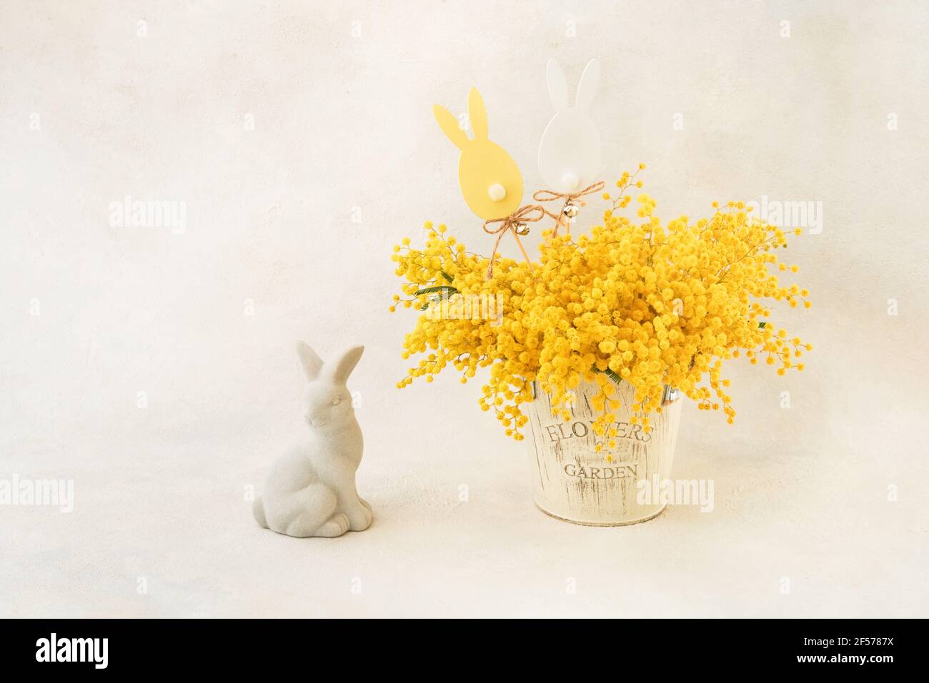 Décoration de Pâques et bouquet de fleurs Mimosa dans un vase sur fond clair. Copier l'espace pour le texte Banque D'Images